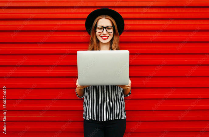 Frau mit Laptop vor roter Wand