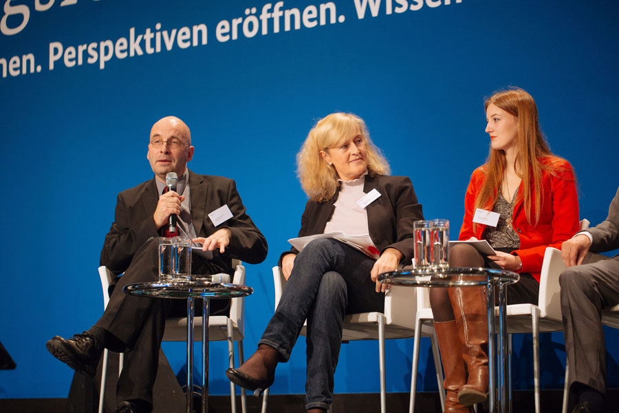 Armin Himmelrath, der ein Mikrofon in der Hand hält, Martina Vetter und Francesca Stiehler sitzen beim moderierten Gespräch