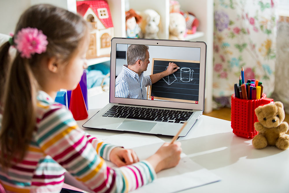 Mädchen sitzt vor einem Laptop beim Onlineunterricht
